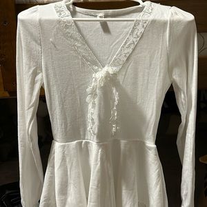 Princess-style dress with long sleeves and a v-neck. It has lace detailing.